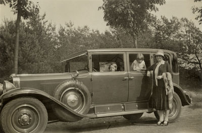 811870 Afbeelding van enkele leden van het gezin van W.H.J. Bruschwiler bij hun auto, in een landelijke omgeving, ...